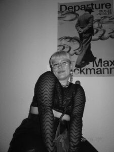 Die Autorin in einem schwarz-weiß Bild. Im Hintergrund ein Bild. 